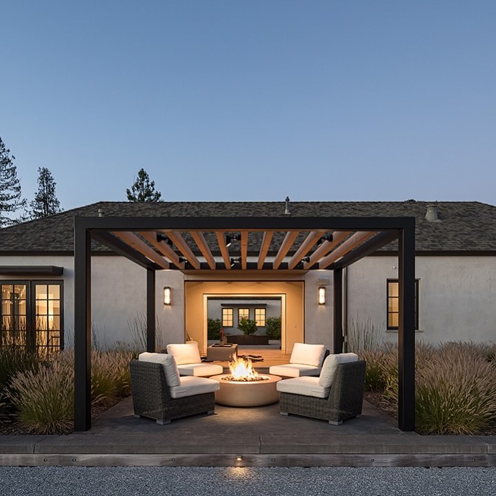 a patio with a fire pit and chairs