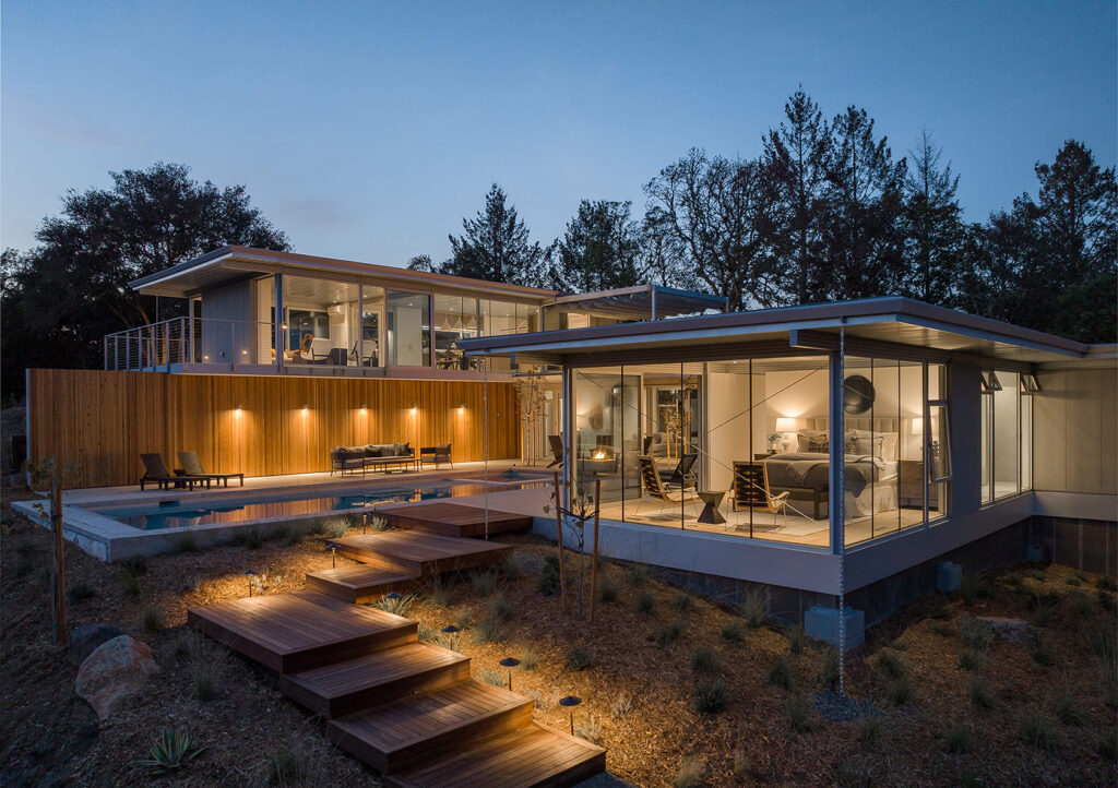 A very modern and minimalist custom home with large windows and a pool perched above the green hills of Santa Rosa California. Views from the home are vast and show off the lush scenery that one can find adjacent to the vineyards of wine country.
