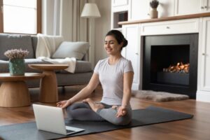 a woman sitting on the floor in front of a laptop