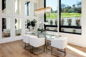 a dining table with white chairs and a chandelier